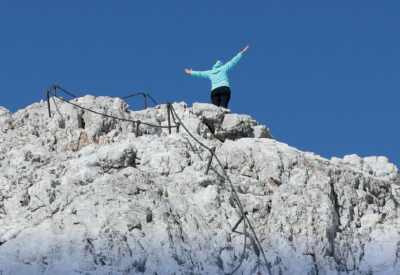 Femme debout sur le sommet d'une montagne avec les bras ouverts