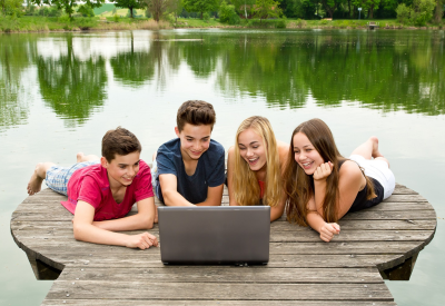 Groupe d'adolescents avec ordinateur portable à l'extérieur dans la nature