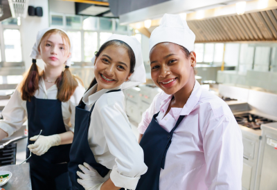 Portrait de groupe d'une jeune femme en train de cuisiner. Cours de cuisine. Classe de cuisine. Groupe de jeunes étudiantes multiethniques heureuses de suivre des cours de cuisine dans une école de cuisine.